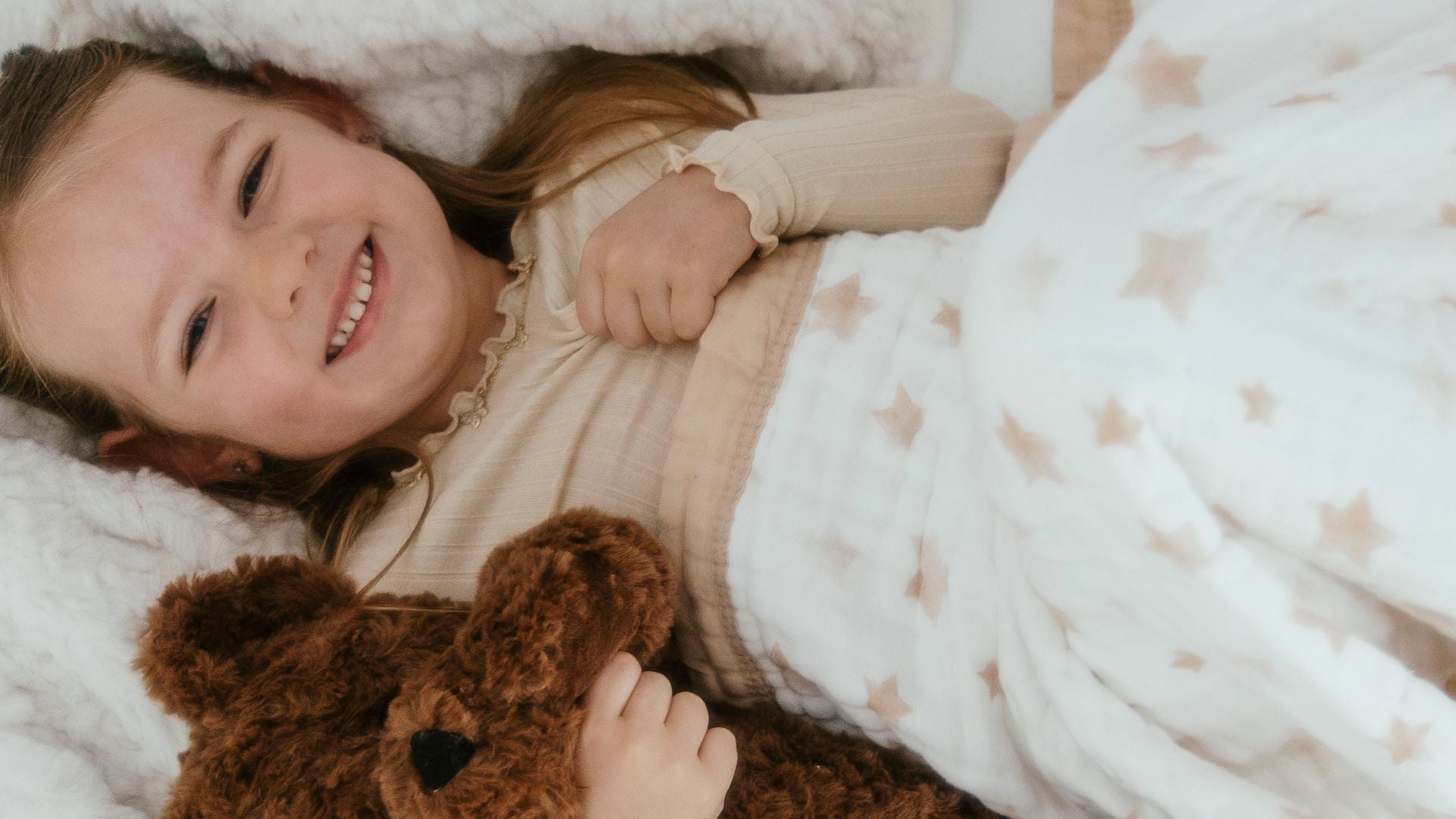 Star Cotton Toddler Quilt by Nachiketa with little girl snuggled up in the blanket with teddy bear