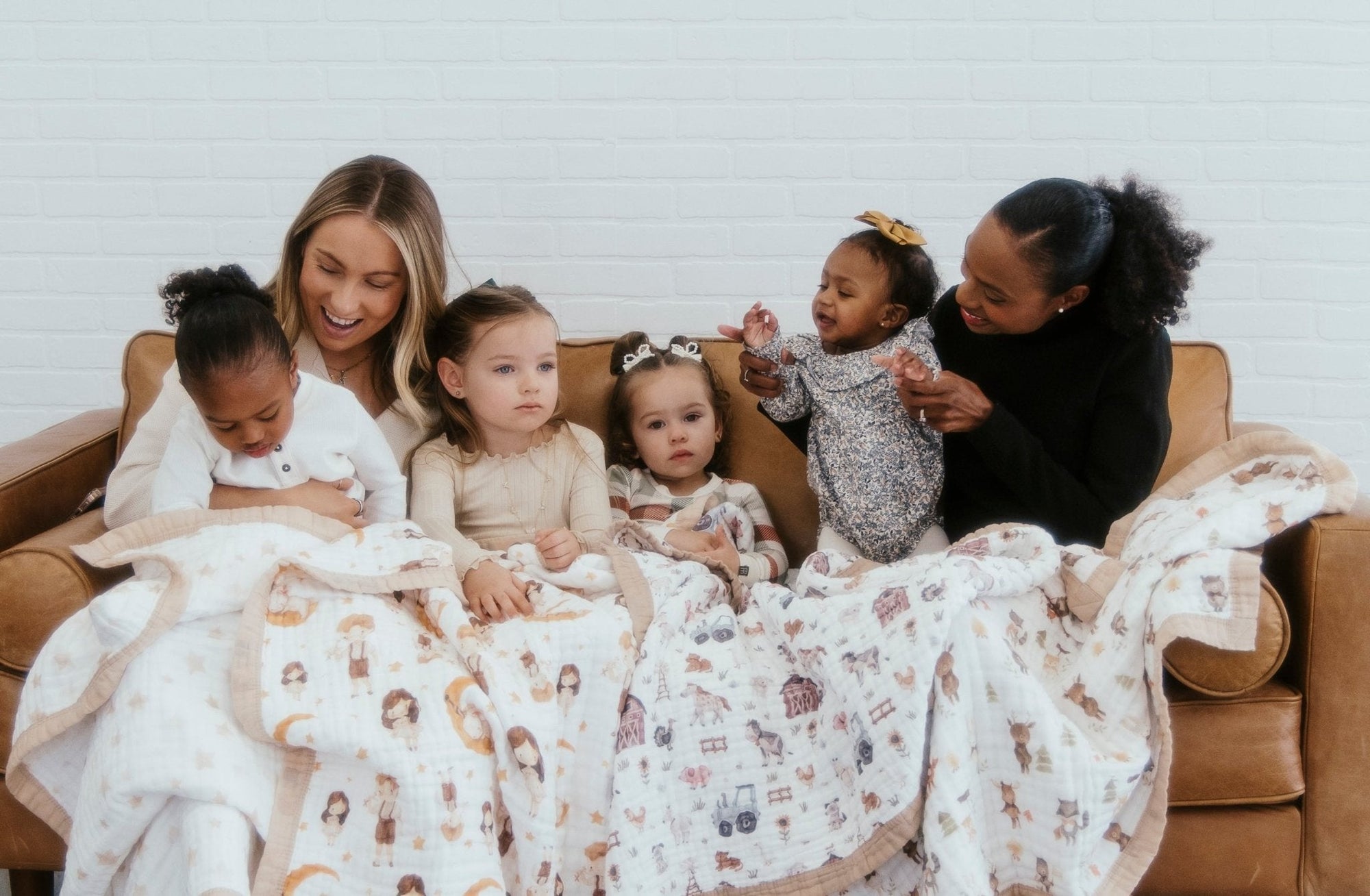 Organic Cotton Baby blankets in multiples with moms with their kids sitting on a sofa